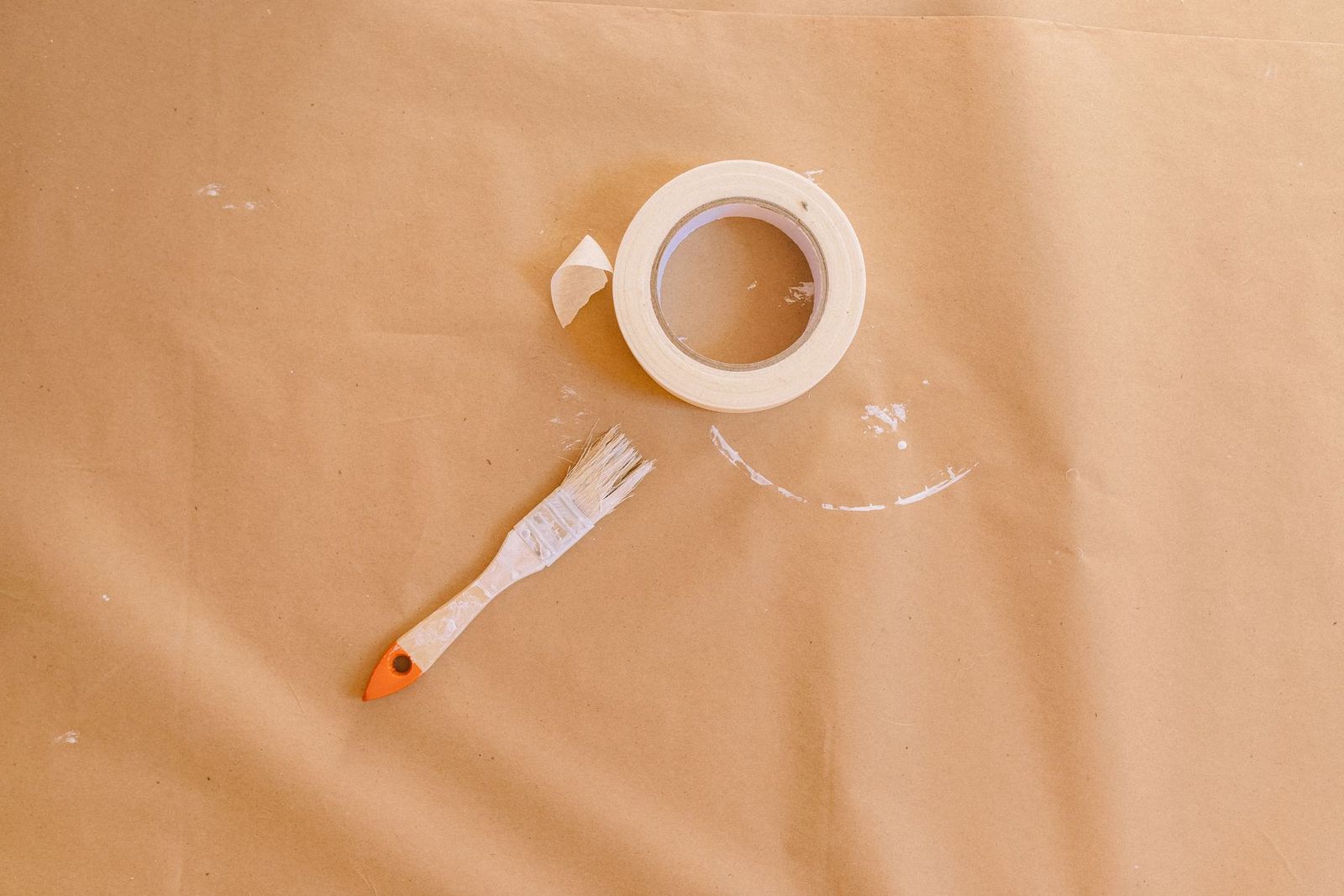 Pinsel und Malerkrepp auf braunem Papier